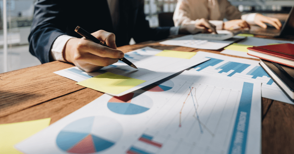 business people sitting at a table with papers and pens representing business continuity planning